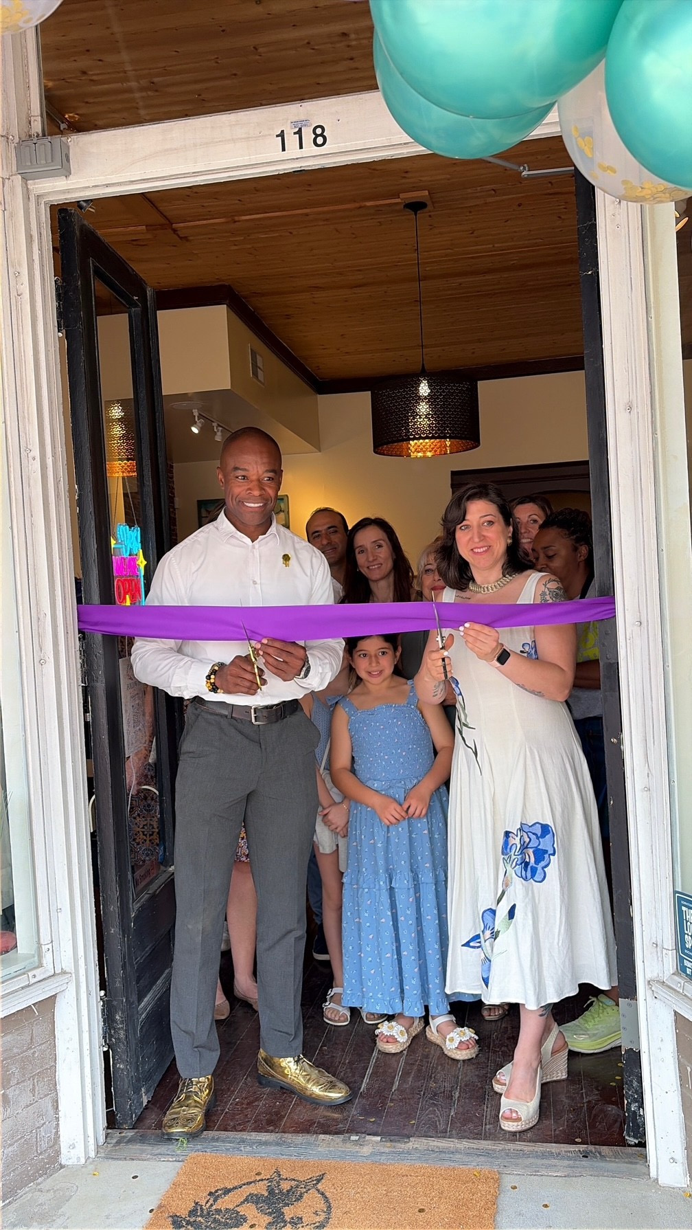 Mayor Jacques K. Gilbert and the Joyfully House family cutting the purple ribbon at 118 N Salem St